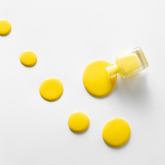 Top view of yellow nail polish on white background