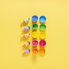 Top view of colorful paint on yellow background