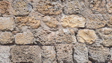 Naklejka premium Old beige stone wall background texture close up