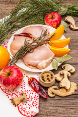 Raw chicken boneless meat with herbs and fruits on plate. Cooking at Christmas time or Thanksgiving Day