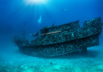 Fototapeta premium Ein Scuba Taucher mit Taschenlampe erforscht ein altes, versunkenes Wrack auf dem Boden des Indischen Ozeans