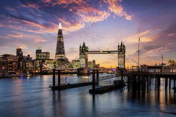 Blick auf die Tower Bridge und die beleuchtete, urbane Skyline von London am Abend, Großbritannien 
