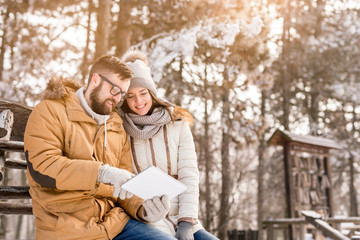Couple using tablet on winter vacation