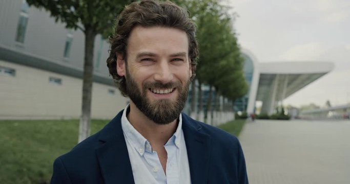 Portrait confident handsome Businessman smiling happy to the Camera. Man proud enjoying successful startup Company near modern Office Center. Man gets real Emotions. Men. Attractive People. Success.