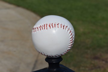 Horizontal baseball on top of a fence post
