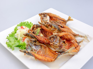 Deep fried fish on white plate, selective focus of Thai meal.