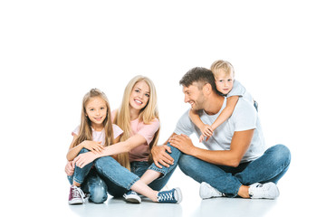 happy parents and children in blue jeans sitting on white