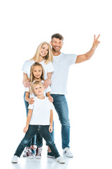 happy man showing peace sign near wife and kids on white