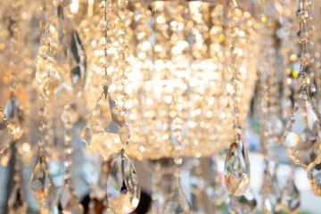luxury hanging crystal chandelier shiny decoration interior , blur bokeh light lamp at background . beautiful electricity expensive furniture .
