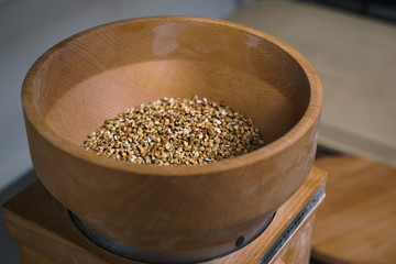 The process of making green buckwheat flour in a wooden hand mill in a small bakery