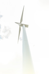 bottom-up view of wind turbine with clouds