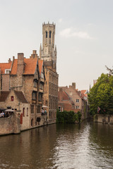 Obraz premium Bruges, Belgium. Medieval ancient houses made of old bricks at water channel with boats in old town. Picturesque landscape.