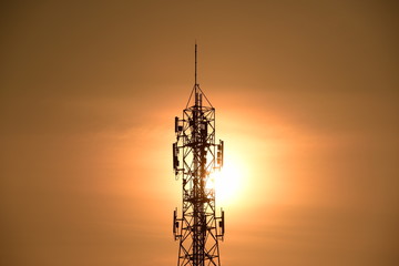 Telecommunication tower with orange sky.Telecommunication towers with TV antennas and satellite dish