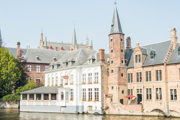 Bruges, Belgium. Medieval ancient houses made of old bricks at water channel with boats in old town. Picturesque landscape.