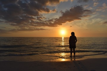 Fototapeta na wymiar silhouette of woman on the beach at sunset