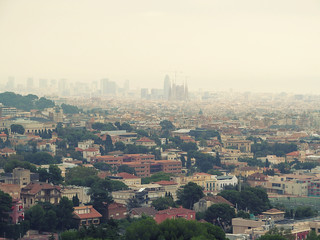 Barcelona panorama with the silhouette of the Sagrada Familia on the horizon on a cloudy foggy day. Beautiful urban landscape of an old tourist city, with blur effect