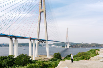 Traveler looks at the Russky Bridge connecting Vladivostok City with the Russky Island over the...