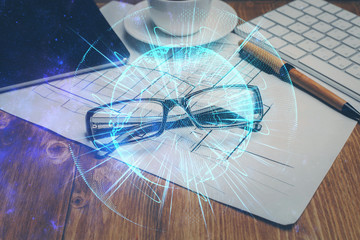 Business theme hologram with glasses on the table background. Concept of search. Double exposure.