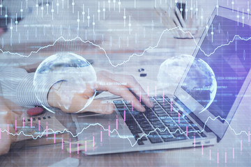 Multi exposure of stock market graph with man working on laptop on background. Concept of financial analysis.