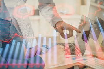 Obraz premium Double exposure of chart with businessman typing on computer in office on background. Concept of hard work.