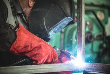 Welder is welding a metal frame.