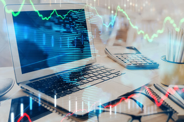 Stock market graph and table with computer background. Double exposure. Concept of financial analysis.