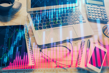 Double exposure of chart and financial info and work space with computer background. Concept of international online trading.