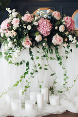 Close-up of roses and greenery wedding decor in sunlight.