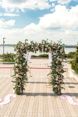 A festive chuppah decorated with fresh beautiful flowers for an outdoor wedding ceremony