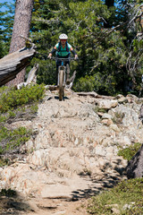 Fototapeta premium female mountain biker on rock garden