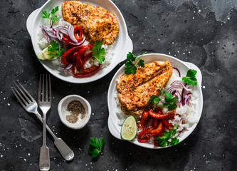 Baked spicy chicken breast with sweet pepper and rice -  delicious mexican style lunch on a dark background, top view. Fajitas bowl