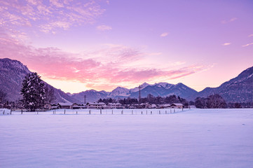 Countryside winter landscape. Alpine mountains background