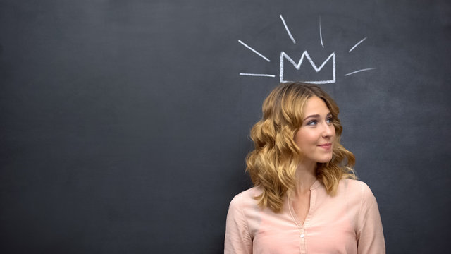 Creative beautiful woman wearing crown drawn on blackboard, artistic imagination
