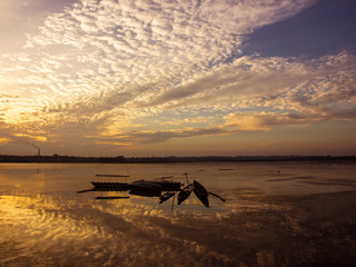 Obraz premium Fishing boats idle beneath cloudy skies on an evening on the Rudrasagar lake in Melaghar in the state of Tripura in Northeast India.