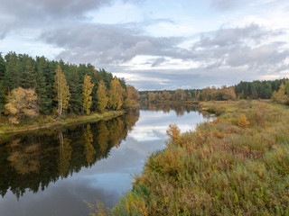 Fototapeta na wymiar autumn landscape with river, calm water, beautiful colorful trees, water reflections, river Gauja, Valmiera, Latvia