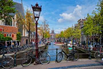 Fietsen in de straat van Amsterdam dichtbij kanaal met oude huizen