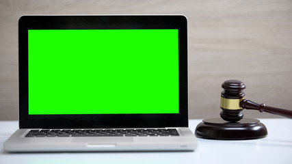 Green screen laptop on table, gavel standing on sound block, fine payment app