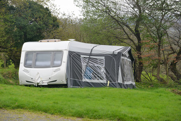 Caravan and awning set up ready for vacation in countryside.
