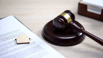 Wooden house sign on document, gavel lying on sound block, property law