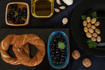 Olives and olives, olive oil on a beautiful stylish dishes, with Cutlery, on a dark background garlic, dill and fresh bread with cereals. The concept of olive products.