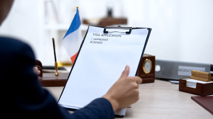 Immigration inspector denying visa application, french flag table, citizenship