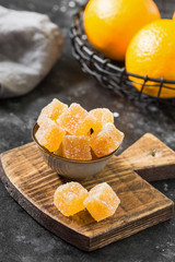 Marmalade sprinkled with sugar in a bowl on a wooden Board. Dark background	
