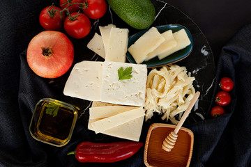 Different varieties of cheese, beautifully laid out in the composition, collected in the middle,...