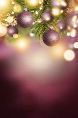 Fir branch with balls and festive lights on the Christmas background with sparkles.
