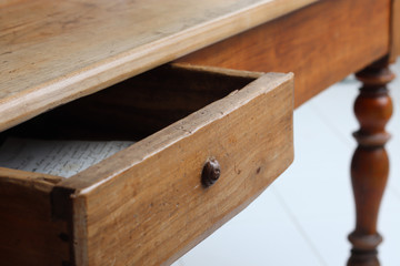 Old vintage wooden table with half-open drawer