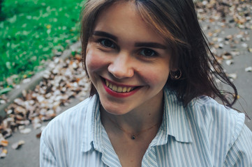 Young beautiful happy girl sitting on the road in the Park and smiling.