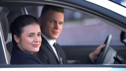 Young couple sitting happily in car after romantic date, loving relationship