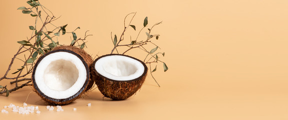 Sliced coconut on a soft orange background, free space for text, banner. Skincare concept, copy space.