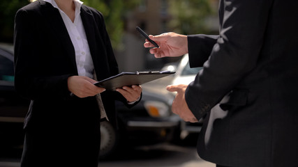 Male agent giving pen to female business partner, signing contract, service deal