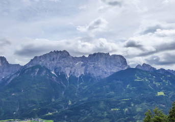 A distanced view on sharp and stony mountain range of Lienz Dolomites, Austria. The slopes are barren, with little grass on it. Dangerous mountain climbing. Clear and beautiful day. Natural beauty